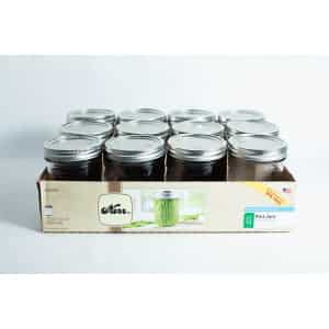 A box of twelve Kerr wide mouth Mason jars, each 473ml pint size with lids and bands, neatly arranged in three rows.