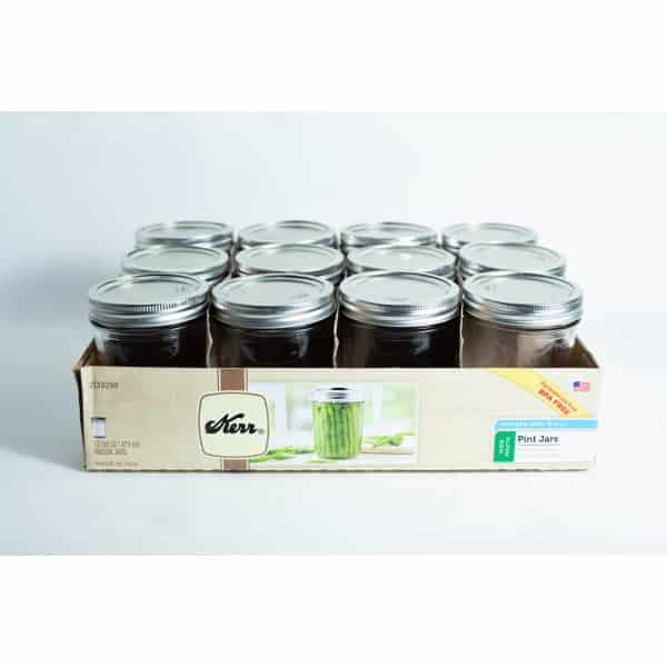 A box of twelve Kerr wide mouth Mason jars, each 473ml pint size with lids and bands, neatly arranged in three rows.