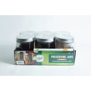 A set of six Ball Mason pint jars with wide mouths are organised in a cardboard box labelled "Preserving Jars" and shown against a white background.