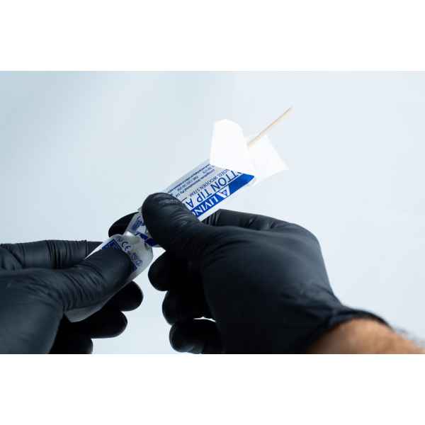 Gloved hands open a sterile wooden tongue depressor from its packaging, ready to use with the Agar petri dish MEA School Science Fun Project Kit for school experiments.