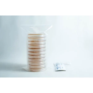 A stack of pre-poured MEAG agar plates (antibacterial) 90mm, sealed in plastic, sits next to a small packet on a white surface.