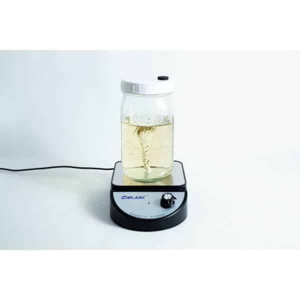 A jar of liquid is being mixed on a Magnetic Stirrer Ciblanc 3500rpm, shown against a plain white background.