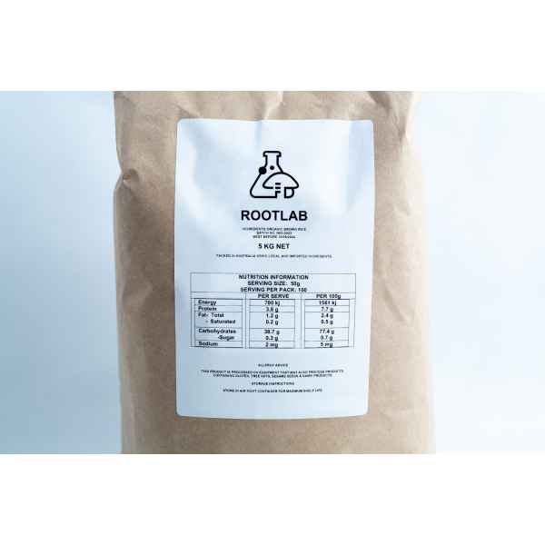 A brown paper bag labelled ROOTLAB with a nutrition information table, science beaker logo, and "Brown Rice Flour 5kg Organic Food Grade" printed on the front.