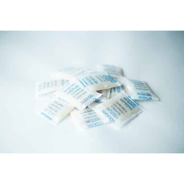 Desiccant Silica Gel 5g | Reusable sachets with blue writing are arranged on a white surface.