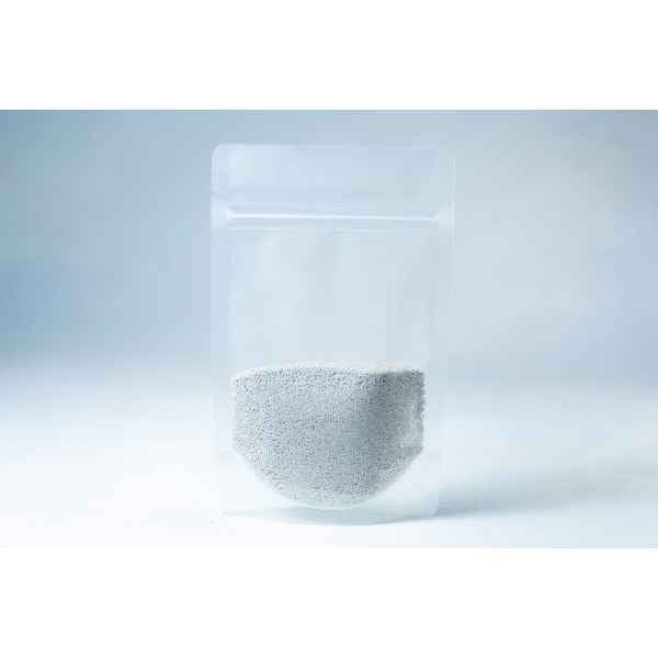 A clear resealable plastic pouch filled halfway with Natural Gypsum coarse grade mushroom supplement grain and substrate, featuring small white gypsum granules, shown on a light background.