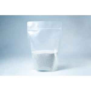 A clear resealable pouch containing white coarse Natural Gypsum mushroom supplement grain and substrate stands on a light background—perfect for storage and use.