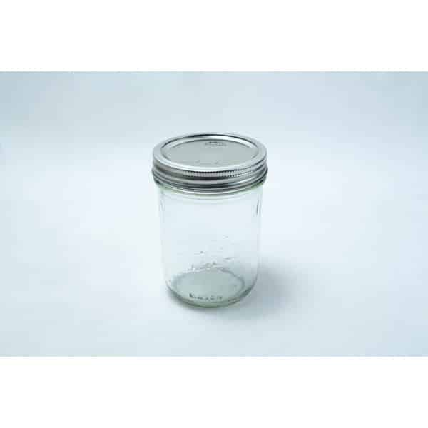 A set of 12 Kerr wide mouth Mason jars, pint size (473ml), with silver lids and bands is displayed on a plain white background.
