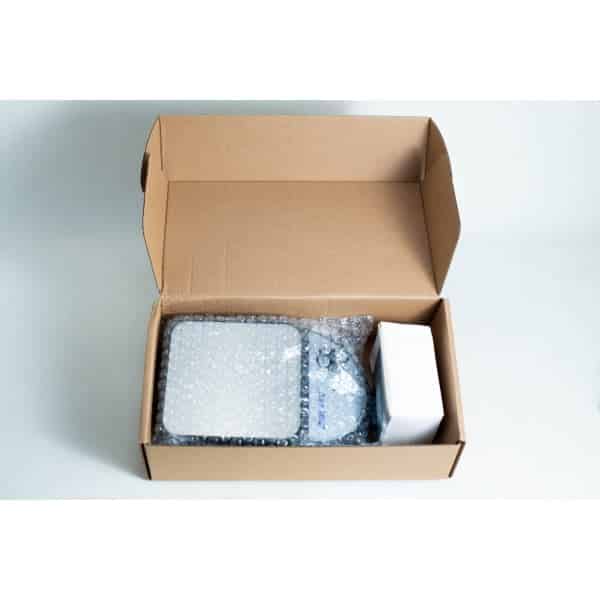 Open cardboard box with bubble-wrapped items and a white rectangular box inside, possibly containing the Magnetic Stirrer Ciblanc 3500rpm—ideal for anyone seeking magnetic stirrer equipment. All items are neatly arranged on a white surface.