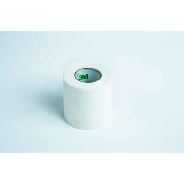 A roll of Micropore tape Mycology autoclavable breathable rests on a light blue background, ready for gentle and secure medical use.