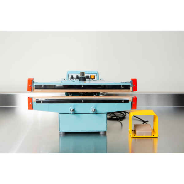 A Heat Sealer 450mm with 10mm Seal | Benchtop Model, featuring control knobs and a yellow foot pedal, sits on a metal counter, designed for reliable industrial sealing.