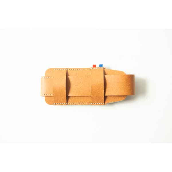 Minimalist brown leather Opinel Sheath with visible stitching, set against a white background—showcasing refined craftsmanship.