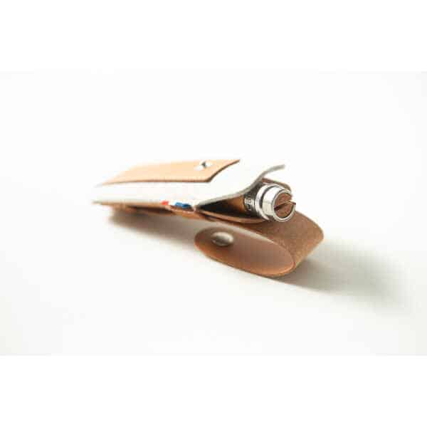 A brown Opinel Sheath holds a metallic pen, photographed on a white background.