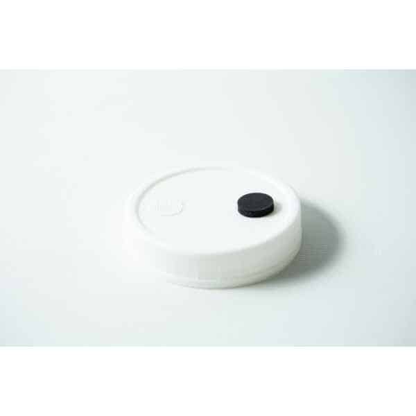 The Mycology pre-made Wide Mouth Mason Jar Lid in white features an injection port and air filter, making it ideal for autoclaving and mycology use.