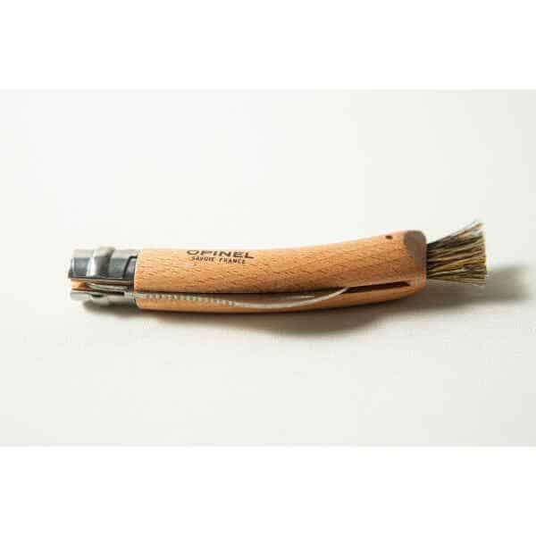 An Opinel No 8 Folding Mushroom Knife with a beech handle and stainless steel blade rests on a white surface.
