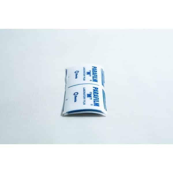 Pre-cut Parafilm strips 10x lab cut film rest on a white surface, making it easy to quickly seal lab containers without the need to cut Parafilm strips by hand.