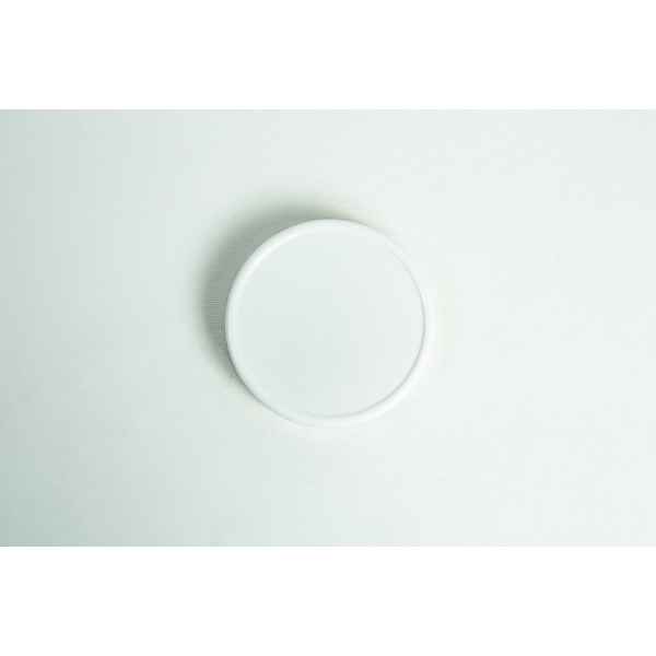 A plain white, wide-mouth 86mm plastic Mason jar lid rests on a simple white surface.