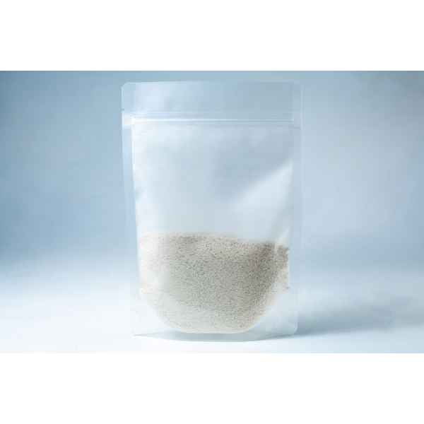 A clear resealable plastic pouch containing Natural Gypsum coarse grade—white granules used as a mushroom supplement for grain and substrate—stands upright on a light background.