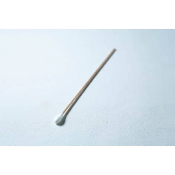 A single sterile cotton wool bud with a wooden stick is placed on a white surface.