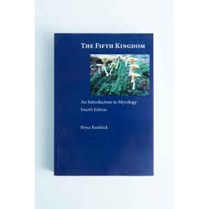 Blue book cover of "The Fifth Kingdom: Book by Bryce Kendrick," a renowned mycology title, featuring mushrooms on a log at the top.