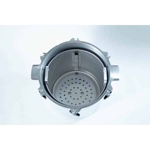 Top view of an empty stainless steel autoclave chamber with a perforated metal tray inside.
