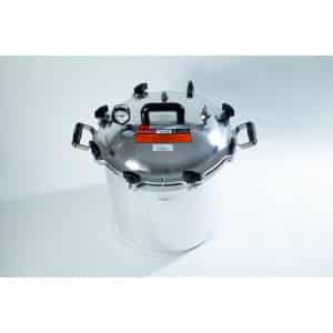 A large stainless steel pressure cooker with a black handle and pressure gauge on a white background.