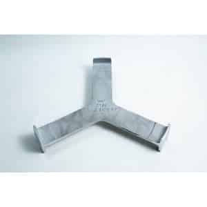 Grey metal object with three prongs and “THIS SIDE UP” engraved at the centre, placed on a white surface.