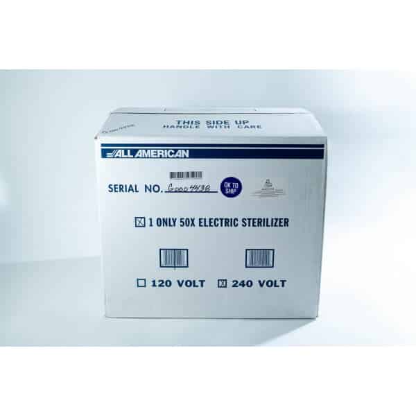 White box labelled All American for a 50X electric steriliser, marked for shipping, with voltage options.