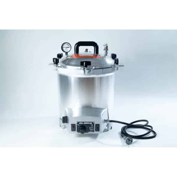 A silver electric pressure cooker with a gauge, black handle, knobs, and a power lead on a white background.