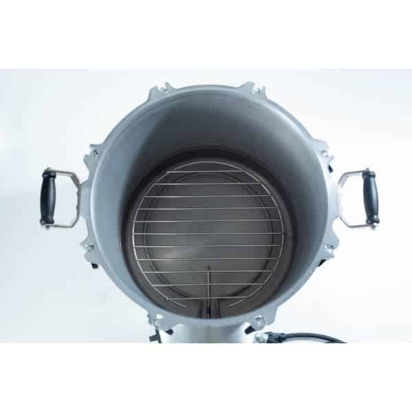 Top view of an empty metal pressure cooker with a round rack and side handles.