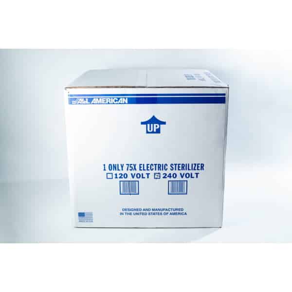 A cardboard box labelled All American containing a 75X electric steriliser, marked UP with voltage options.