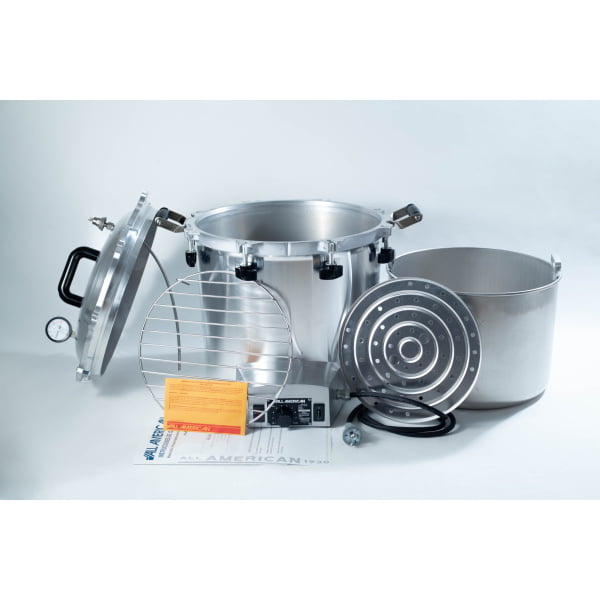 Large silver autoclave with lid, metal rack, inner pot, instructions, and power lead displayed on a white background.