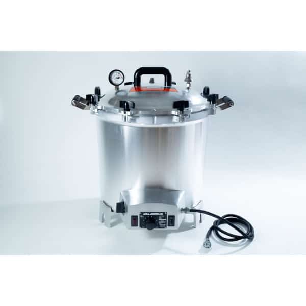 A stainless steel electric pressure cooker with a gauge, handle, and attached power lead.