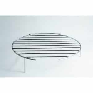 Round metal grill rack with three legs, standing on a white surface, photographed against a plain background.