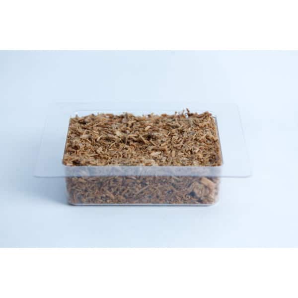 A clear plastic container filled with brown wood chips on a white background.