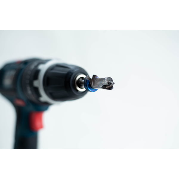 Close-up of a power drill with a specialised drill bit, set against a plain white background.