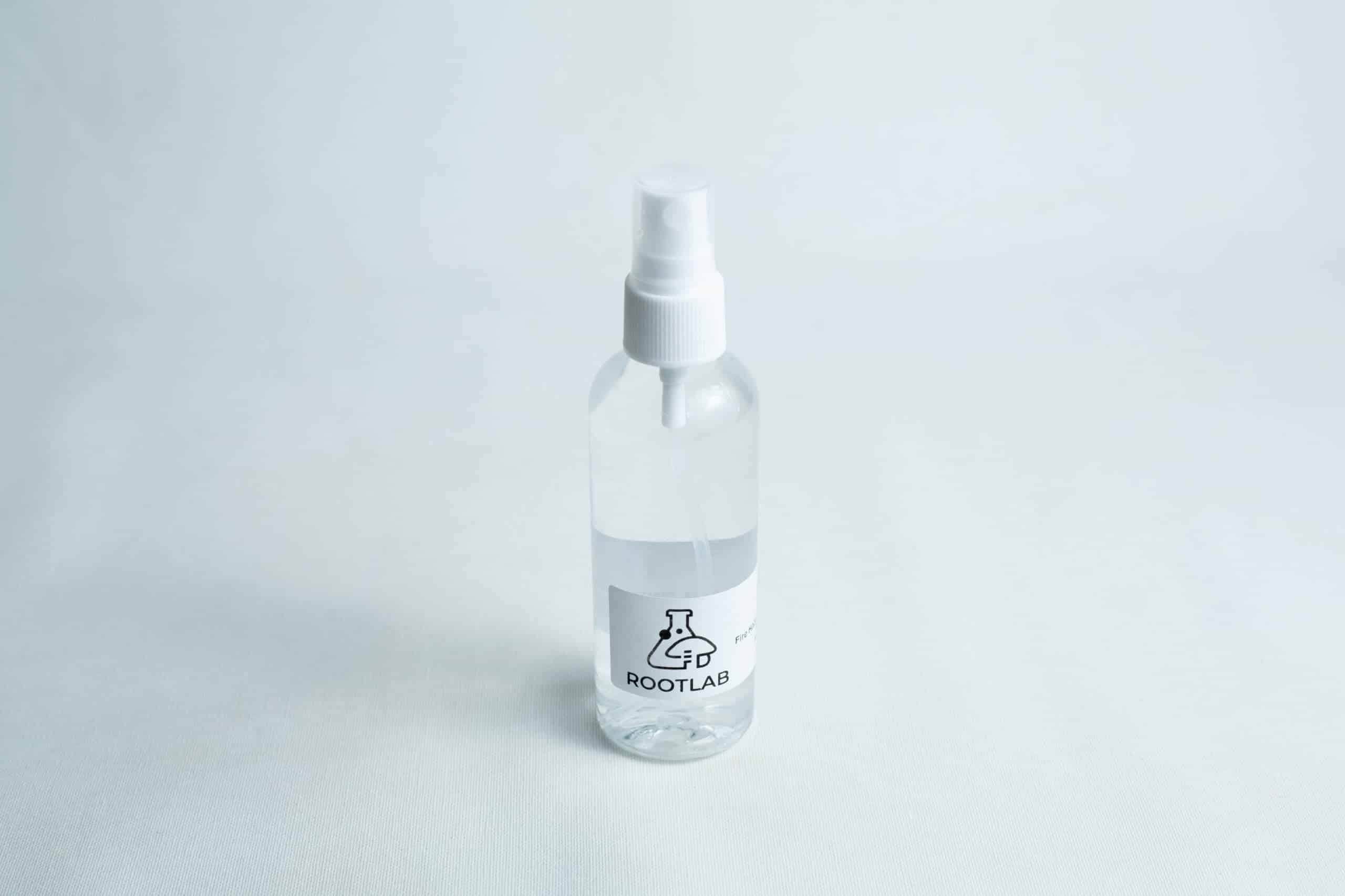 A clear 100ml spray bottle labelled ROOTLAB with a laboratory flask logo, containing 70% isopropyl alcohol, is placed on a white background.