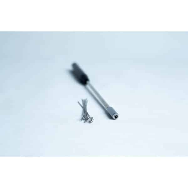 A precision screwdriver and several small screws on a white surface.