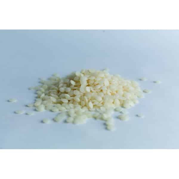 A small pile of uncooked white rice grains on a plain, light surface.
