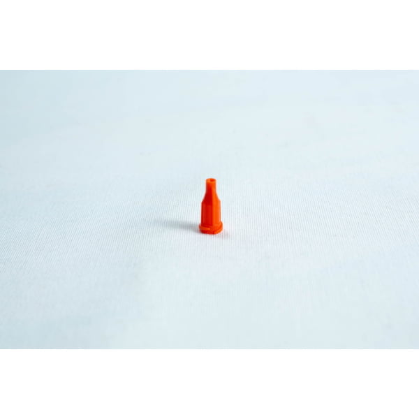 A small orange plastic nozzle stands upright on a plain white surface.