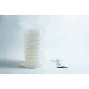 A stack of sealed petri dishes and a small packet on a white surface with a plain background.