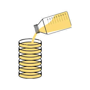 A bottle pours yellow liquid into a stack of round glass tumblers.
