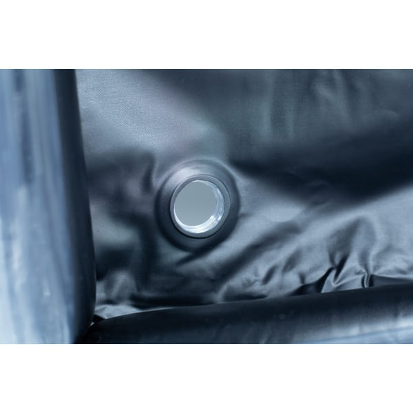 Close-up of a circular metal drain hole in a dark, waterproof material, possibly an inflatable object.