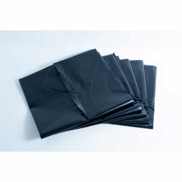A stack of black plastic bin bags laid out on a white surface.