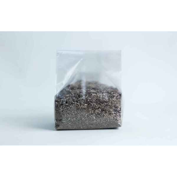 A clear plastic bag filled with a mixture of small, dark and light grains—perfect for use with the Monotub Mushroom Growing Kit-Premium—set against a plain background.
