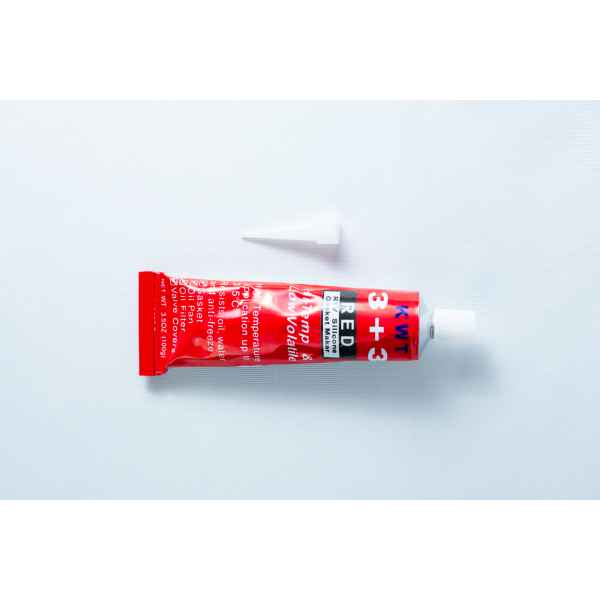 A red tube of High Temperature RTV Silicone-Red with a white cap placed above it on a white background.