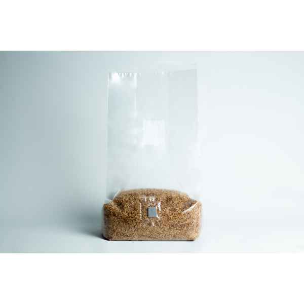 A clear plastic bag filled with brown sugar sits on a plain white background.