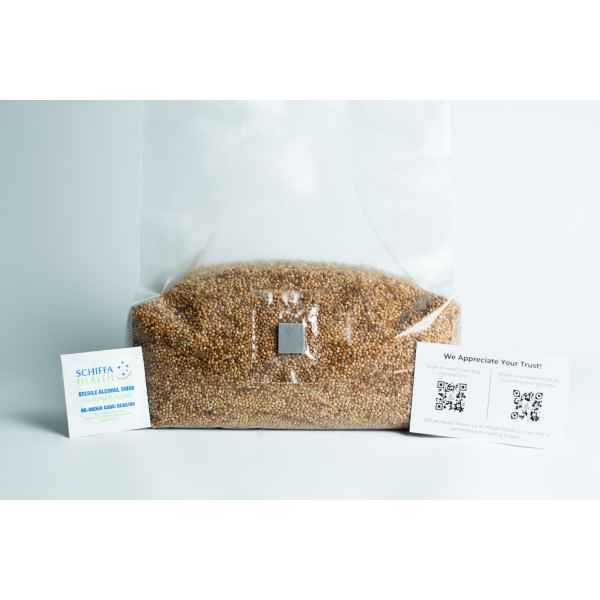 Clear bag of seeds with two business cards placed on either side against a white background.