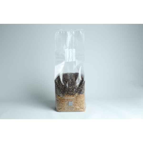 A clear plastic bag filled with black and brown grains on a plain white background.