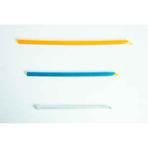 Three colourful twist ties, orange, blue, and clear, are laid out horizontally on a white background.
