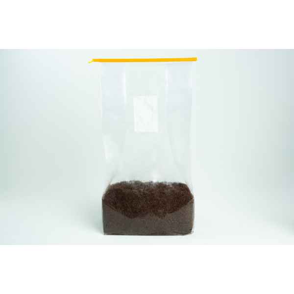 Clear plastic bag with a yellow zip, partially filled with loose black tea leaves.